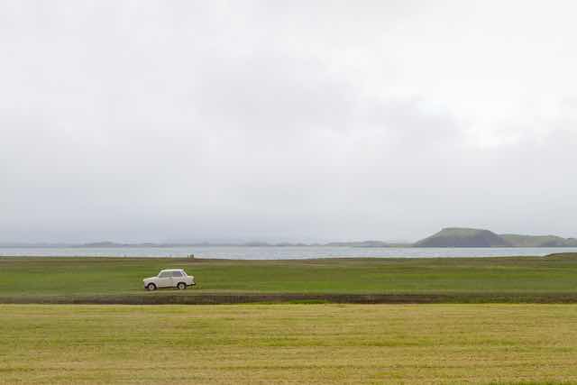 Vintage Car on Green Field by Lake Mývatn Iceland