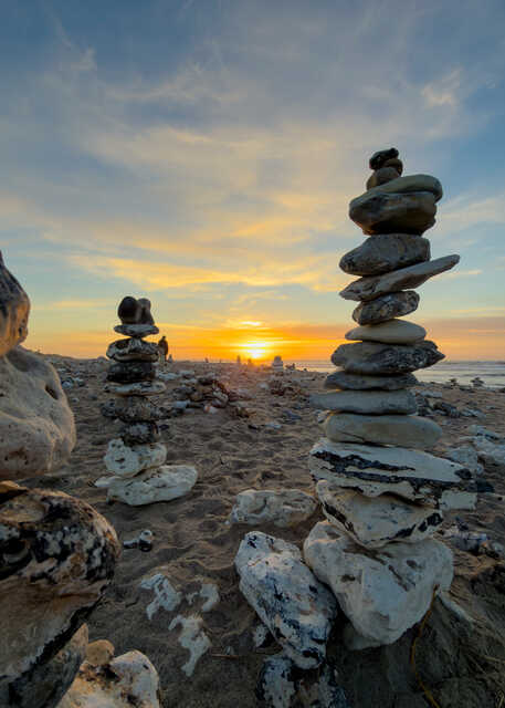 Stacked Stone Cairns on Klitmøller Beach at Sunset