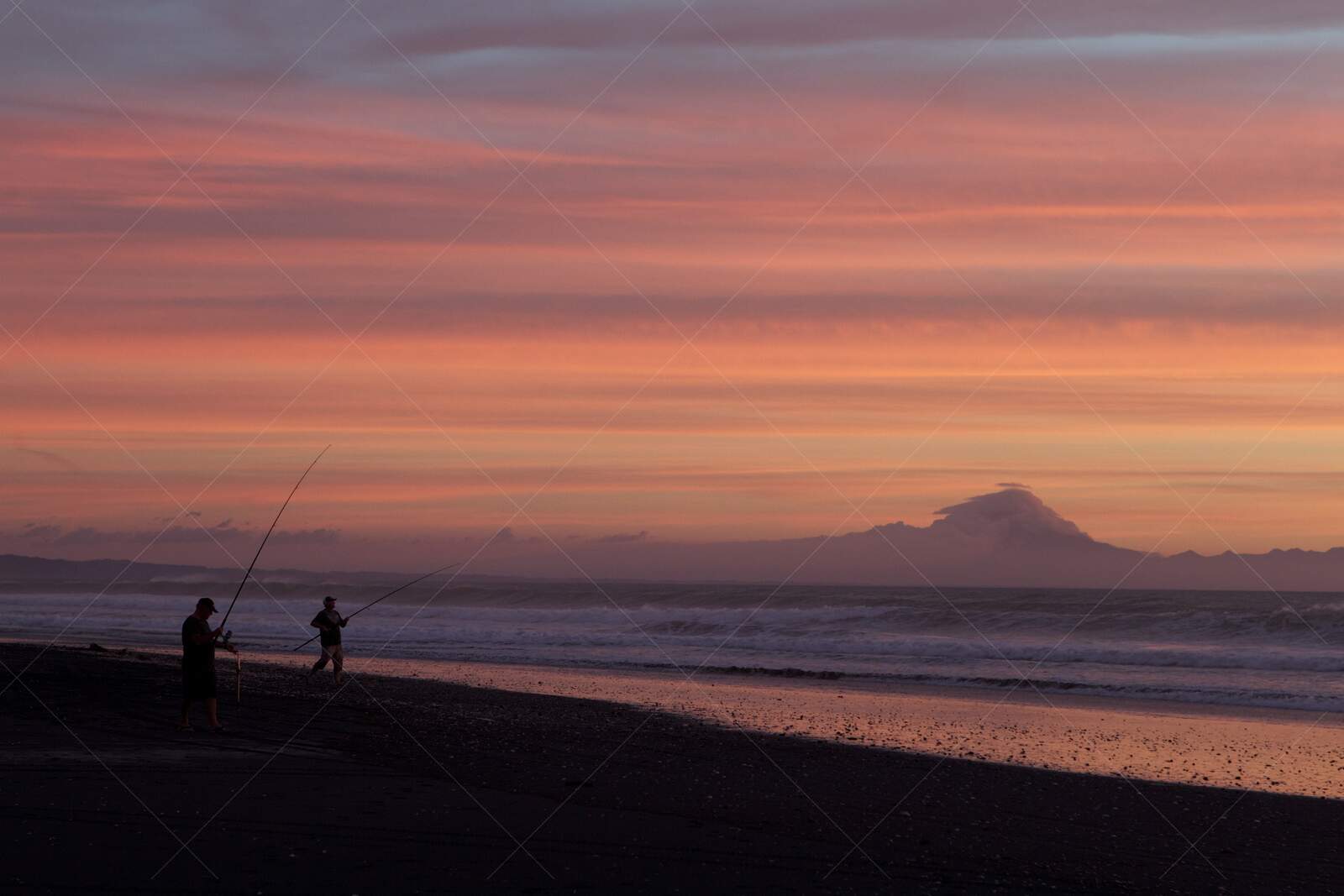 Fishing at sunset on New Zealand North Island beach
