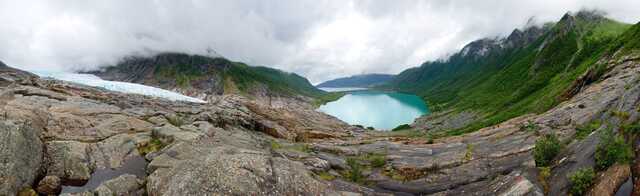 Svartisen glacier and turquoise lake surrounded by misty mountains