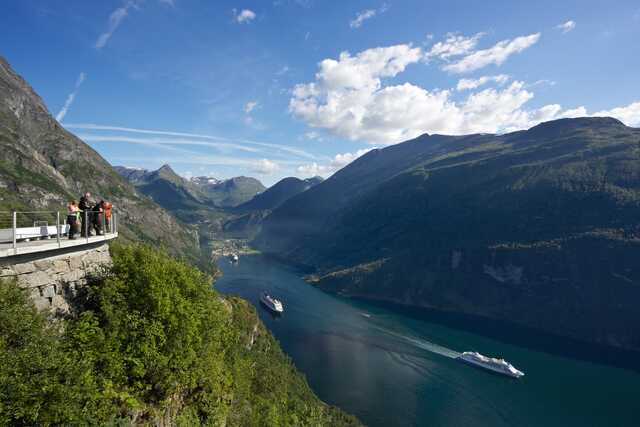 Tourists overlooking Geirangerfjord with cruise ships Norway