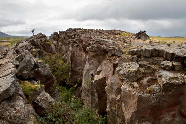 Hiker on rocky cliff in Þingeyjarsveit Iceland