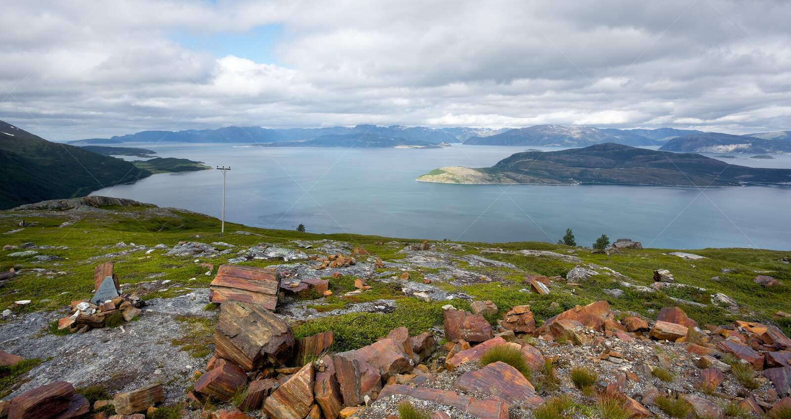 Scenic fjord view with rocky foreground and distant mountains