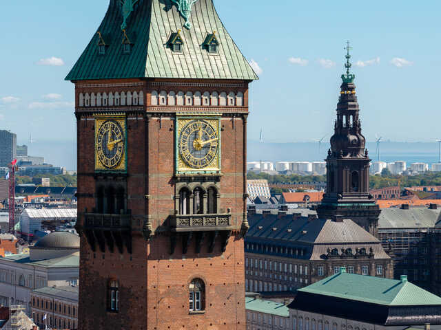 Historic clock tower and spire in Copenhagen cityscape