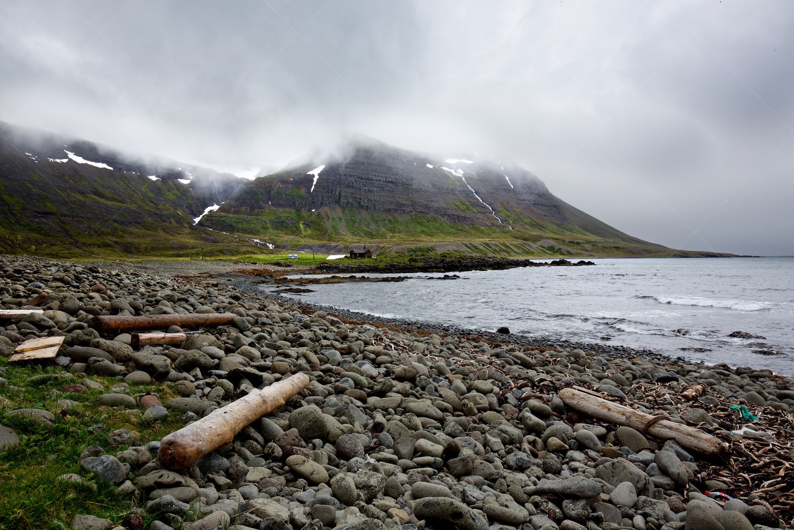 Rocky coastline with misty mountains in Westfjords Iceland