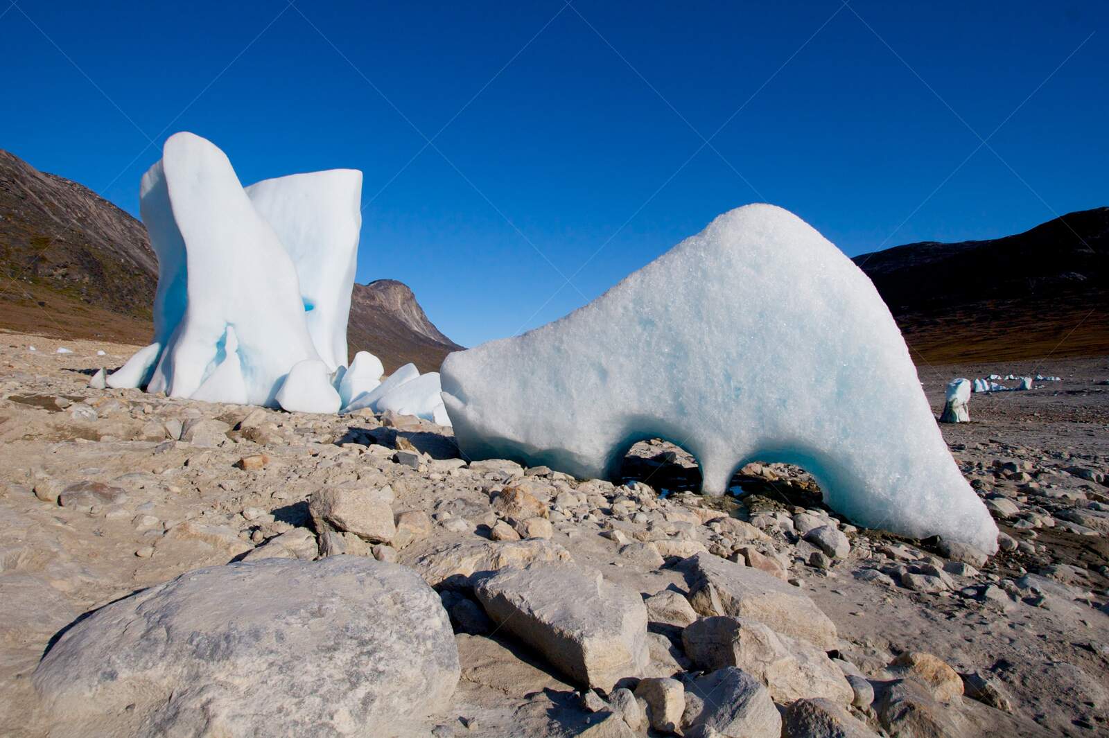 Stranded iceberg on rocky Arctic terrain