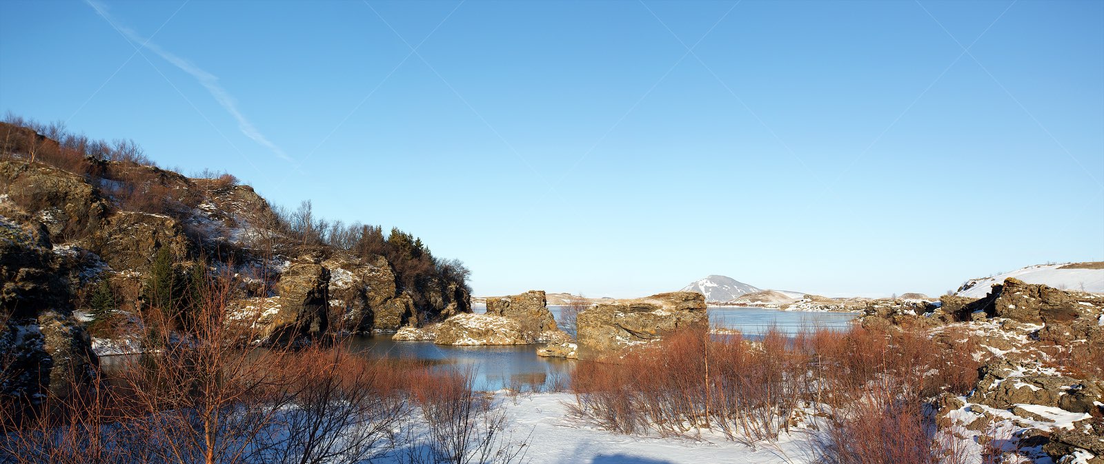 Snowy Mývatn Lake with Volcanic Rock Formations Iceland
