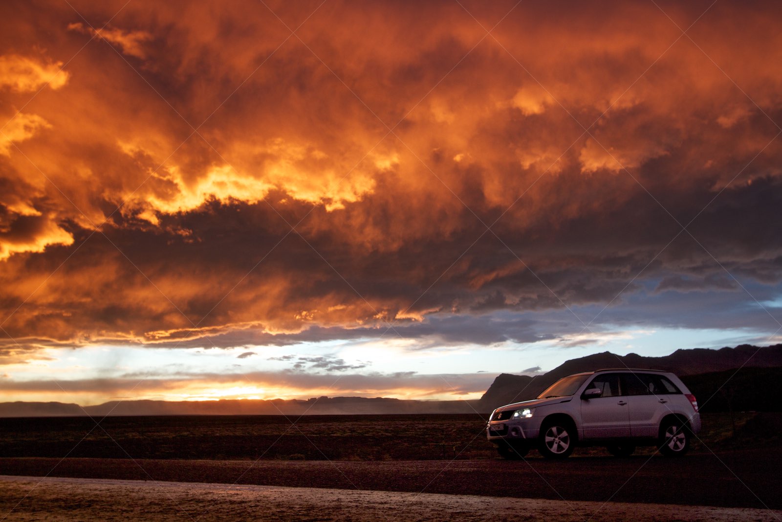 4x4 SUV at dramatic sunset in Icelandic wilderness