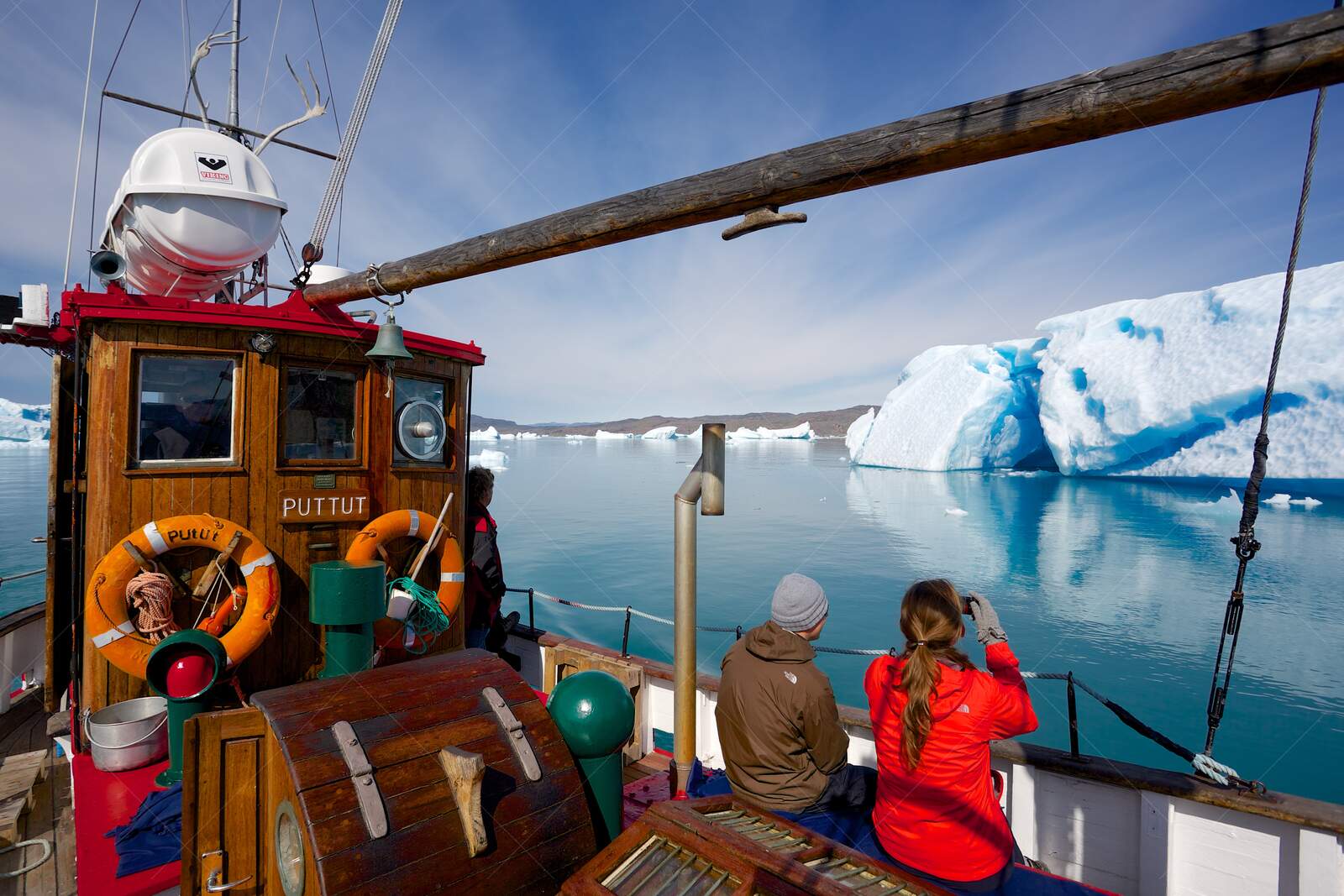 Tourists on Boat Exploring Icebergs in Arctic Waters