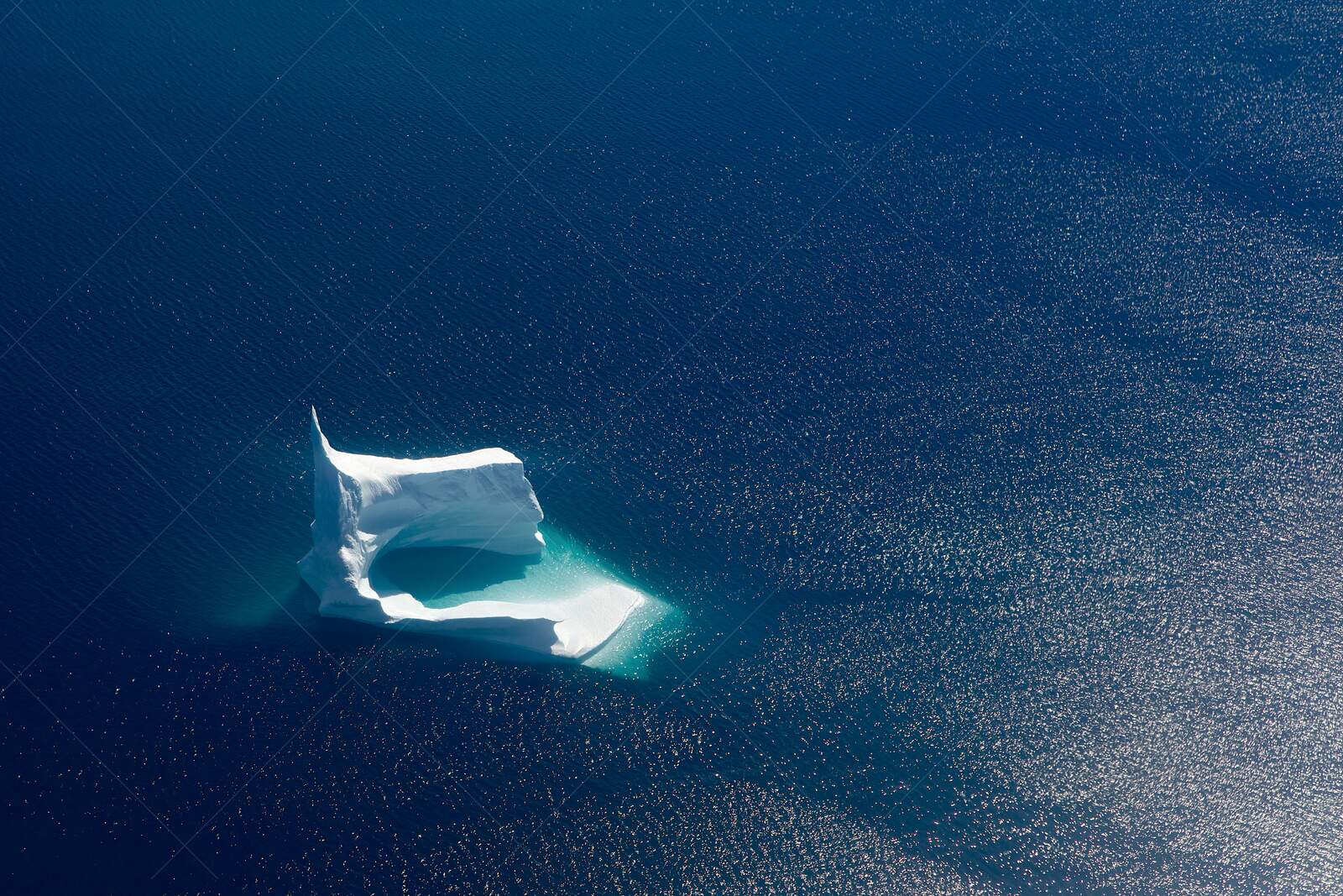 Aerial view of unique iceberg in deep blue ocean