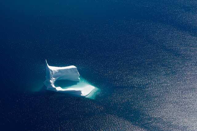 Aerial view of unique iceberg in deep blue ocean