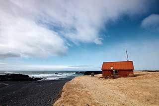 Rusty abandoned coastal cabin on rugged shore