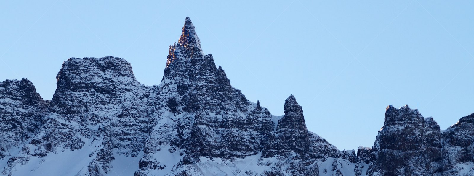 Snow-covered jagged mountain peaks in Öxnadalur Iceland