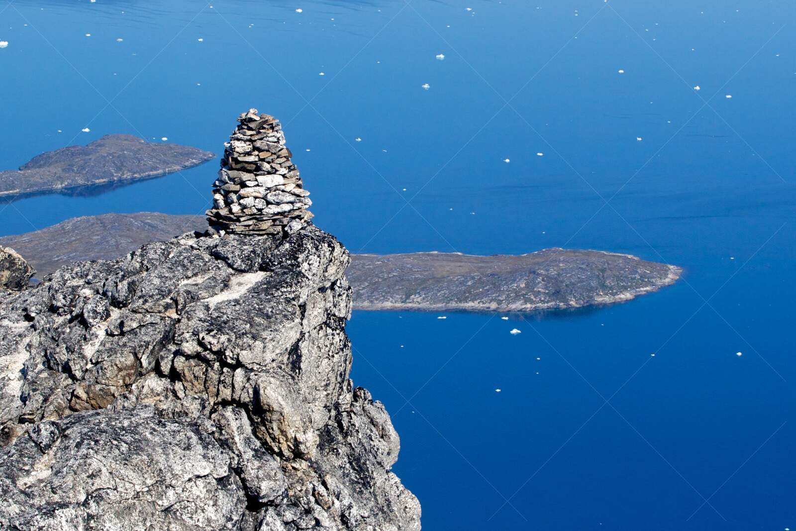 Cairn on Sermitsiaq, overlooking blue fjord near Nuuk