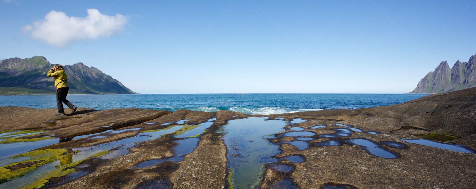 Person Exploring Rocky Shoreline at Senja Norway
