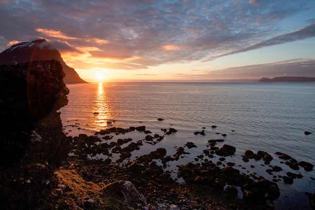 Djúpvegur. Sunset over rocky coastline in Bolungarvík, Iceland