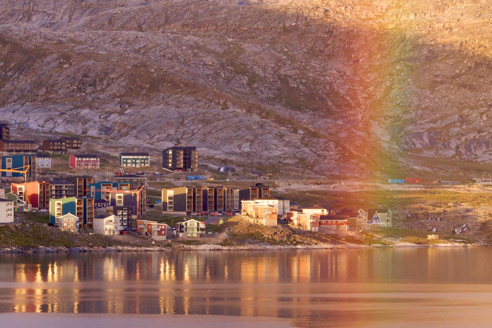 Rainbow over colorful Qinngorput neighborhood in Greenland